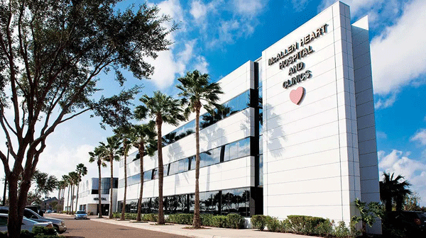 STHS Heart - Texas Hospital Association Exterior view of a modern hospital building with a heart emblem and palm trees along the street.