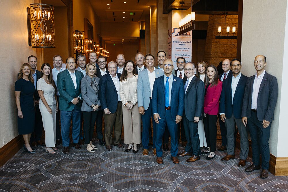 The THA Board of Trustees showed up in force at the 2026 THA Annual Conference in Fort Worth - Texas Hospital Association Group of business professionals in suits and dresses posing for a group photo in a hotel conference hallway.