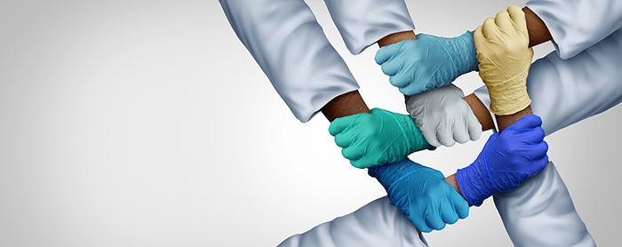 supportive-hands - Texas Hospital Association hands in medical gloves criss-crossed to hold each other's wrist