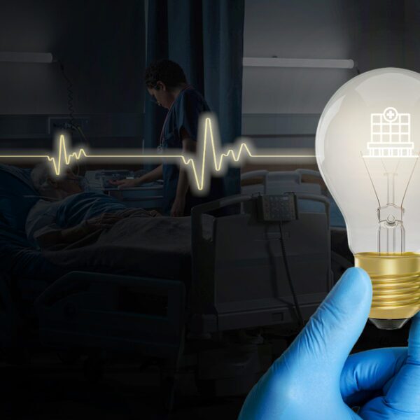 Gloved hand holding a glowing light bulb in front of a hospital ICU scene with a patient and a heartbeat line across the image.