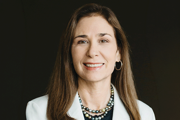 Cris Daskevich - Texas Hospital Association Professional head-and-shoulders portrait of a smiling woman with long brown hair, wearing a light blazer and layered pearl necklaces.