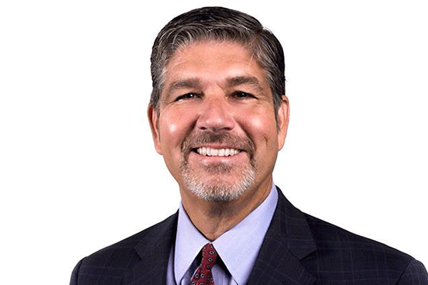 Russell Weaver - Texas Hospital Association Head-and-shoulders portrait of a smiling man in a dark suit and red tie against a white background, a professional business headshot.