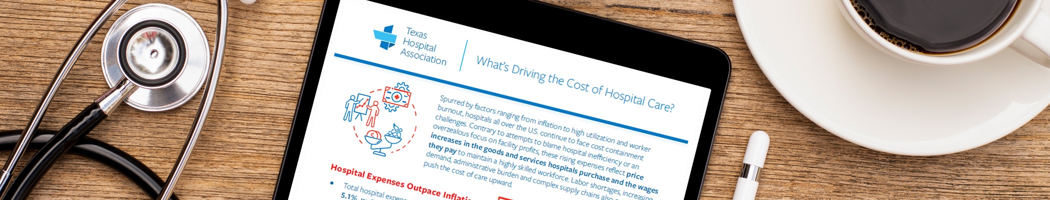 White Papers and Reports - Texas Hospital Association Tablet showing a report titled What's Driving the Cost of Hospital Care? from Texas Hospital Association, on a wooden desk with a stethoscope and coffee cup nearby.
