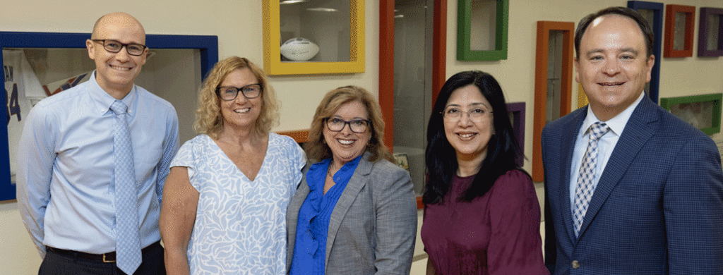 Bill Aston 2025 Award for Quality: Non-Research/Non-Teaching Hospital/Health System - Texas Hospital Association Five professionals posing together in an office, smiling for a group photo in business attire.