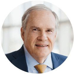 John Hawkins - Texas Hospital Association Headshot of a man in a navy suit and yellow tie, smiling, with a bright office background.