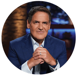 Mark Cuban - Texas Hospital Association TV host or presenter in a blue blazer sits in a studio, hands clasped in front, looking at the camera
