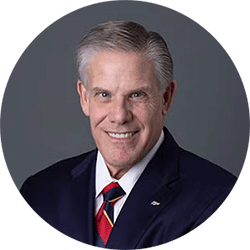 Rick Pollack - Texas Hospital Association Circular head-and-shoulders portrait of a smiling man in a dark suit, white shirt, and striped tie; professional look.
