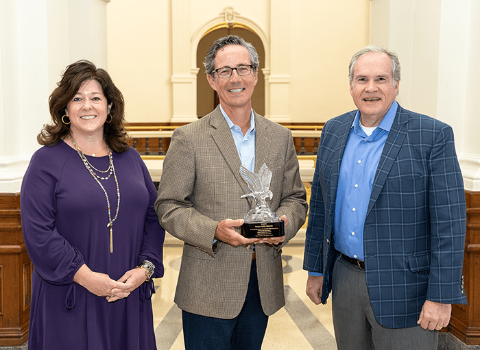 Hawkins and Jennifer Banda presenting an award to Senator Kelly Hancock - Texas Hospital Association Hawkins-Banda-Hancock