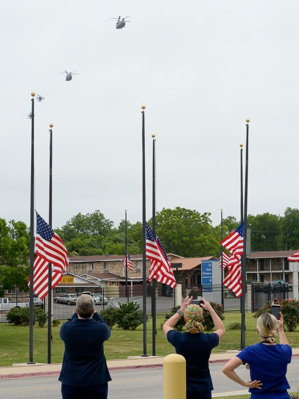 flyover-ctvhcs_lg - Texas Hospital Association staff at the Central Texas Veterans Health Care System standing near flags at half mast as helicopters approach