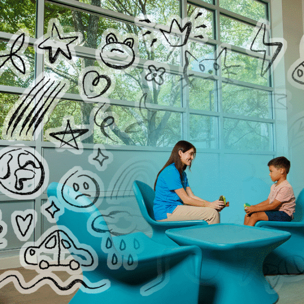 Woman and child talk in a bright blue seating area, doodles on glass walls convey a playful, welcoming space