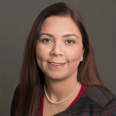 Harpreet Sharma - Texas Hospital Association Head-and-shoulders portrait of a smiling woman with long brown hair, wearing a burgundy top, striped blazer, and a pearl necklace.