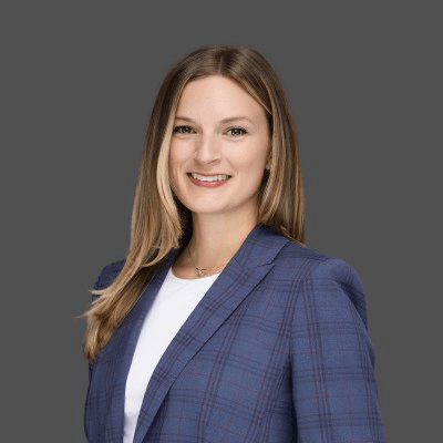 Rachel Sloan - Texas Hospital Association Smiling professional headshot of a woman in a blue plaid blazer against a gray backdrop.